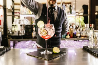 Expert barman is making cocktail at night club.